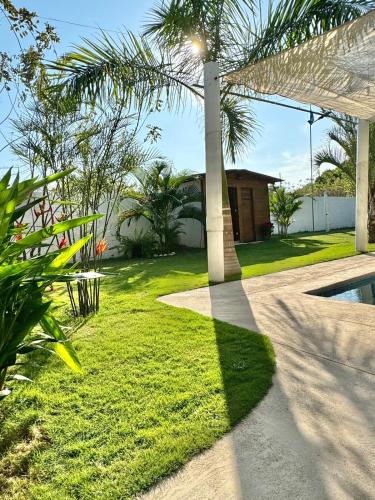 einen Garten mit einer Palme und einem Pool in der Unterkunft Casa Doral Monterrico in Monterrico