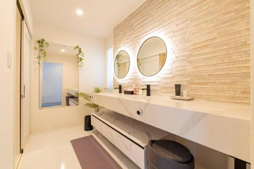 Un baño con dos lavabos y un espejo. en Bridge View Villa, en Awaji