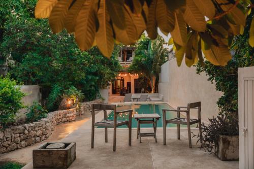 ein Tisch und Stühle auf einer Terrasse mit einem Tisch und Bäumen in der Unterkunft Casa De Cortes in Mérida