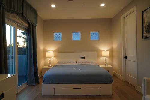 a bedroom with a bed and two lamps on two tables at Modern comfort, prime location, 360 views, 4 BR entire house in San Diego