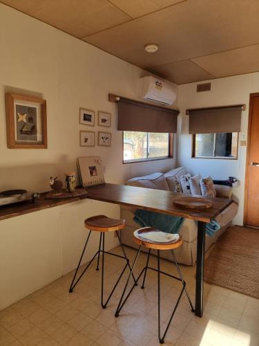 a kitchen with a table and two stools in a room at Farmstay in Elingamite North