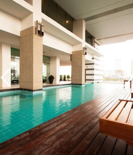 a swimming pool with a bench in a building at Free Airport Pick Up ! 12th Floor Cozy Studio Room, 5 mins walk to IconSiam & BTS in Bangkok