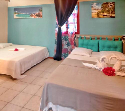 Dos camas en una habitación con paredes azules. en Maison charmante à Plessis Nogent avec piscine partagée, en Sainte-Rose