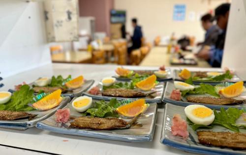 a buffet line with plates of food with eggs and vegetables at ビジネスホテル美咲 in Sakaide