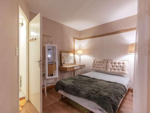 une chambre avec un grand lit et un miroir dans l'établissement Studio central 2-4 pers, terrasse équipée, proche thermes et randos - FR-1-401-311, à Cauterets