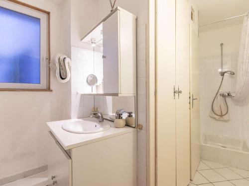une salle de bain blanche avec un lavabo et une douche dans l'établissement Studio central 2-4 pers, terrasse équipée, proche thermes et randos - FR-1-401-311, à Cauterets
