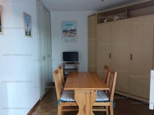 une salle à manger avec une table et des chaises en bois dans l'établissement Appartement lumineux avec balcon près du lac - FR-1-295-204, aux Angles