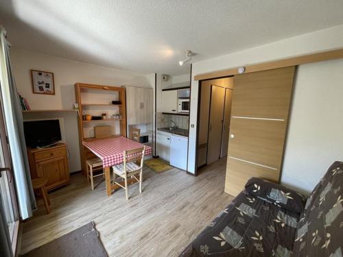 une petite pièce avec une table et une cuisine dans l'établissement Studio-cabine avec balcon proche pistes et parking - FR-1-787-113, à Laveissière