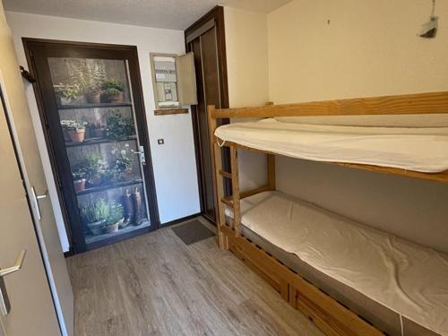 une chambre avec deux lits superposés et une fenêtre dans l'établissement Studio-cabine avec balcon proche pistes et parking - FR-1-787-113, à Laveissière