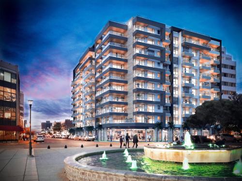 a large apartment building with a fountain in front of it at Caleta Design - Alojamientos in Puerto Madryn