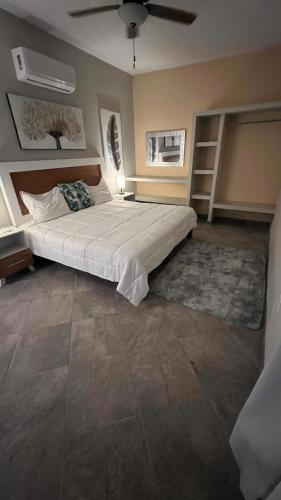 a bedroom with a large bed and a ceiling fan at sicilian villa in Mezcales