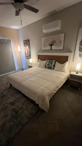 a large bed in a bedroom with two lamps at sicilian villa in Mezcales