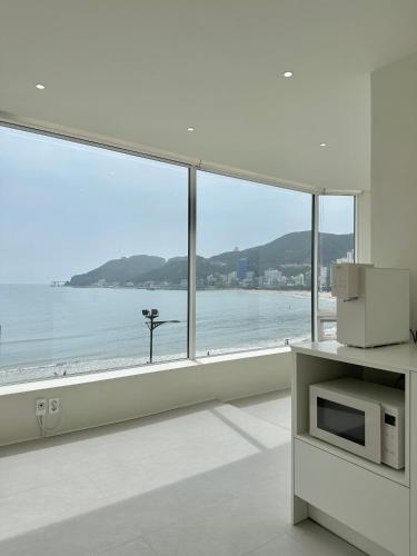 a living room with a large window overlooking the ocean at HoHo House Songjeong in Busan