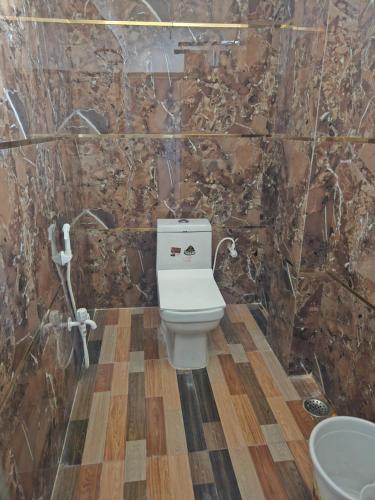 a bathroom with a toilet and a stone wall at Hotel Shri Ram Inn in Ara
