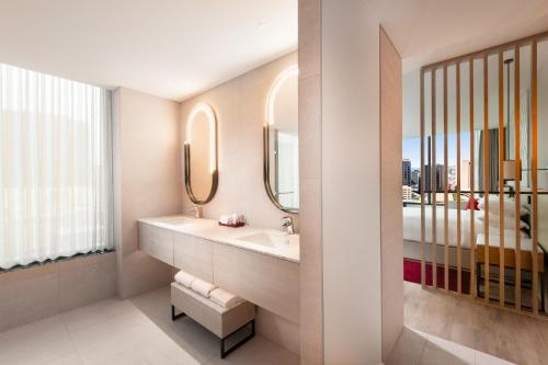a bathroom with a sink and two mirrors at Adelaide Marriott Hotel in Adelaide