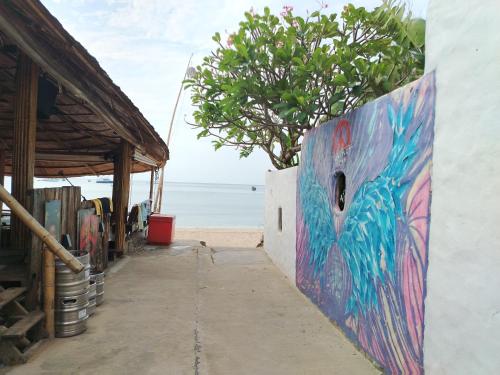 a mural on the side of a building next to the beach at Hayar House's Cabin house at kantiang bay in Ko Bu Bu