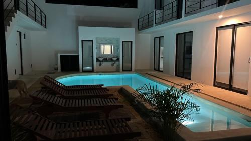 a swimming pool in a house with chairs at Apartamentos Marea CLOSE TO THE AIRPORT in Cancún