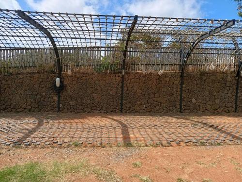 a chain link fence with a stone wall at 墾丁勿忘我城堡莊園 in Hengchun