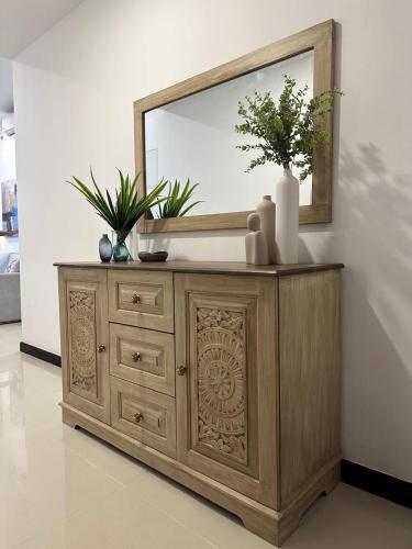 a wooden dresser with a mirror on top of it at Colombo, Trizen Luxury Apartments, Sri Lanka in Colombo