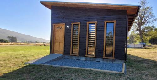 a tiny house with a door and windows at Cabaña Nahuelbuta Adventure in Cañete