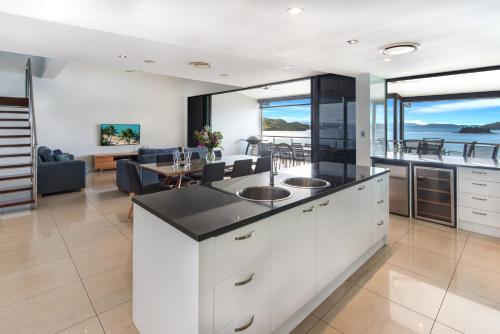 a kitchen with two sinks and a living room at Edge Apartments on Hamilton Island by HIHA in Hamilton Island