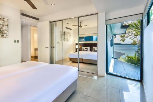 a bedroom with a bed and a view of the ocean at Edge Apartments on Hamilton Island by HIHA in Hamilton Island