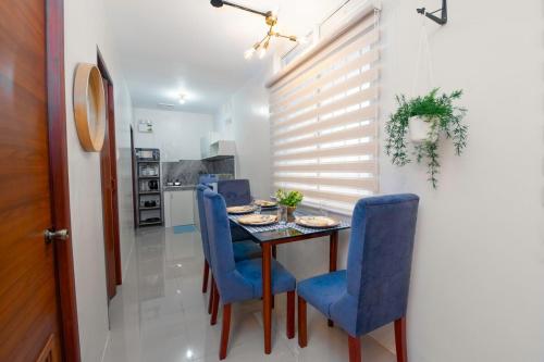 a dining room with a table and blue chairs at Stylish & Modern Stay in Batangas City - Unit 106 in Batangas City