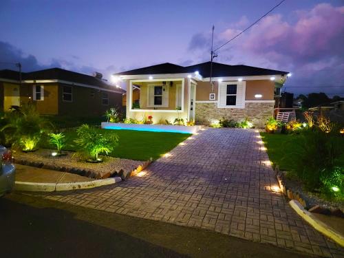 a house with a driveway at night with lights at The Surada Bay in Old Harbour