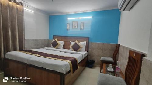 a bedroom with a bed and a blue wall at Hotel Moon Chanakyapuri Satya Niketan- Couple Friendly in New Delhi