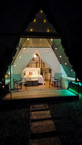 a tent with a bed and chairs in it at night at Flora Glamping de Abuela in Fortuna