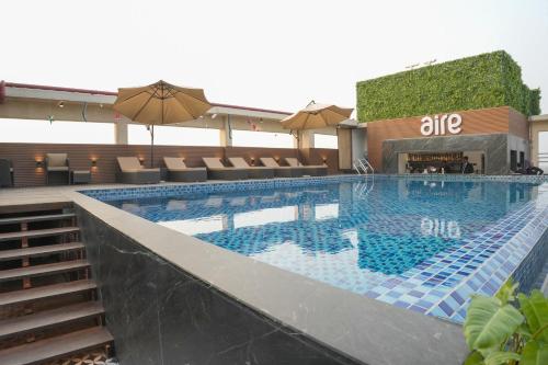 a large swimming pool with umbrellas in a hotel at Hotel SOOT in Kolkata