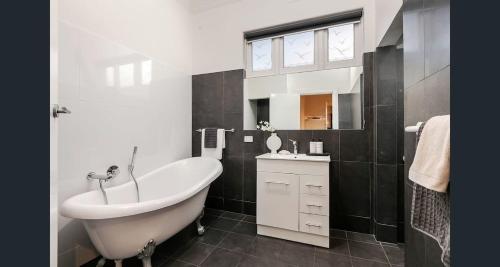 North AdelaideにあるMedindie Home - Close to Adelaide Cityのバスタブと洗面台のあるバスルーム