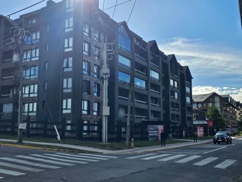 un gran edificio negro en una calle de la ciudad en 2D apartment and 2 baths, 4 P, temperate pool, en Puerto Varas
