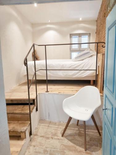 Cette chambre comprend des lits superposés et une chaise blanche. dans l'établissement Appartement spacieux à Algajola, à Algajola