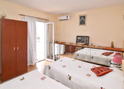 a room with two beds and a desk with a window at Spacious villa with sea view in Trou D'Eau Douce in Trou dʼ Eau Douce