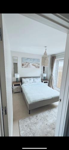 a white bedroom with a bed and a window at 3 Bedroom Beautiful Home with Garden, AC, Hot Tub in Portsmouth
