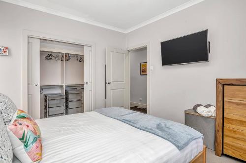 a bedroom with a bed and a flat screen tv at Relaxing Getaway Steps from Grange Beach in Grange