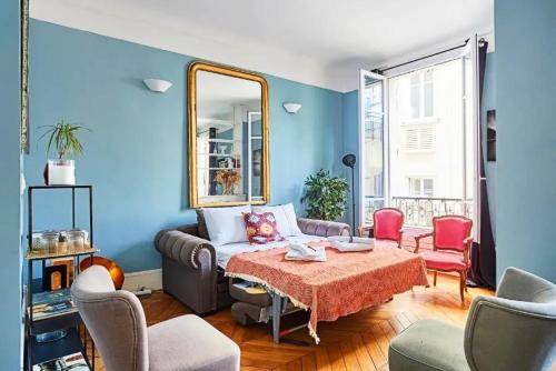 un salon avec un canapé et un miroir dans l'établissement Appartement moderne à Paris près des Champs-Élysées, à Paris