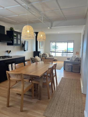 Un comedor y una sala de estar con mesa y sillas. en Waters Edge, en Marion Bay