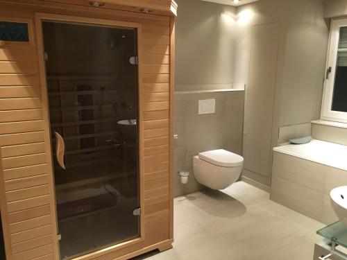 ein Bad mit einem WC und einer Glasdusche in der Unterkunft Moselschön Das Ferienhaus in Brodenbach