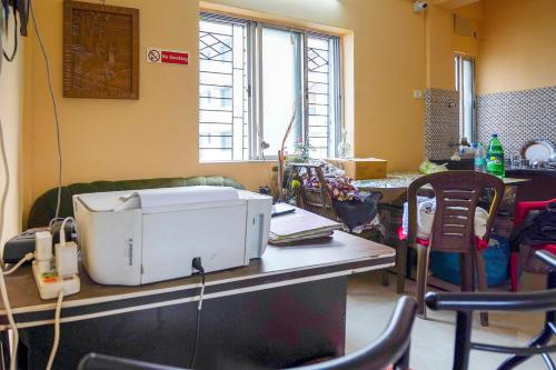 a room with a table with a printer on it at Hotel O Urban Village Guest House in Kolkata
