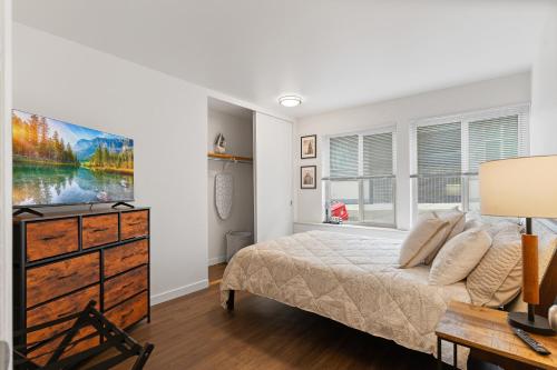 a bedroom with a bed and a dresser and a desk at Chez Alphonse in Seattle