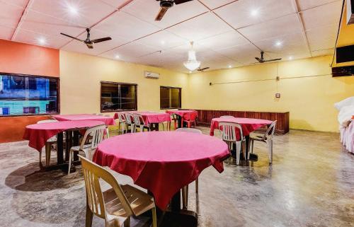a dining room with tables and chairs with red table cloth at SPOT ON Durba 2 in Tezpur