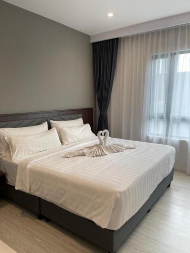 a bedroom with a large white bed with a window at Suasana Suites Johor Bahru City Centre in Johor Bahru