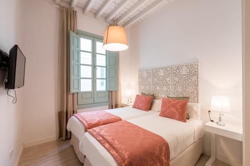 ein Schlafzimmer mit einem großen Bett und einem Fenster in der Unterkunft Palacio Cabrera - Lillo in Granada