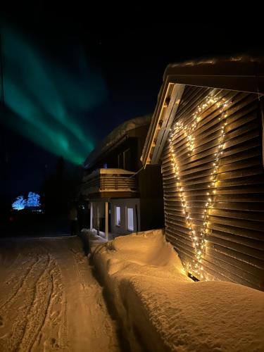 a heart drawn on the side of a building with lights at House with charm, valley with lots of northern lights, Breivikeidet in Tromsø