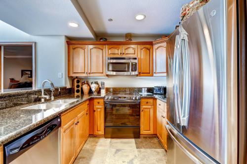 a kitchen with wooden cabinets and a stainless steel refrigerator at St. James Place in Beaver Creek