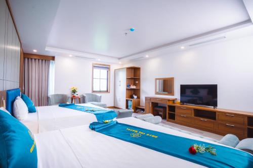 a hotel room with two beds and a flat screen tv at Crystal Holiday Hotel Ha long - 3 Loc Vung Street in Ha Long