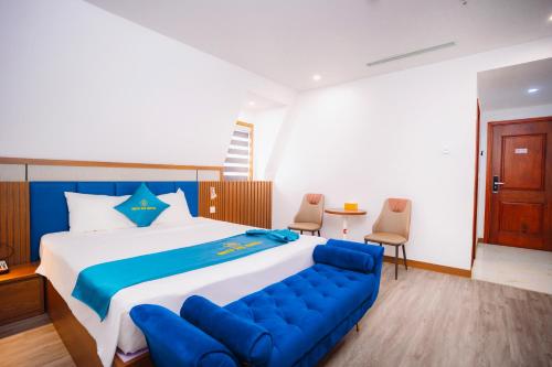 a bedroom with a large bed with a blue couch at Crystal Holiday Hotel Ha long - 3 Loc Vung Street in Ha Long