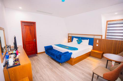 a bedroom with a bed and a blue chair at Crystal Holiday Hotel Ha long - 3 Loc Vung Street in Ha Long